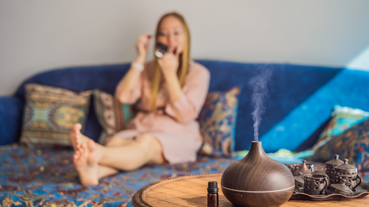 High-quality 500ml ultrasonic wood-grain diffuser with remote control, color lighting, and essential oil bottles beside it.