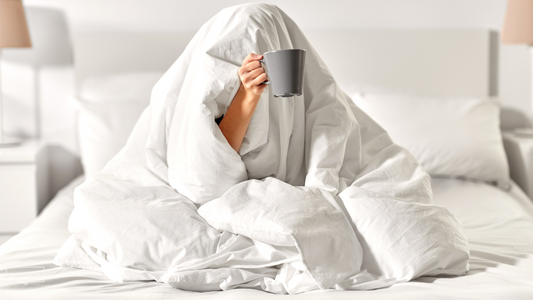 A cozy living room scene with a heated blanket draped over a couch, a steaming cup of tea nearby.